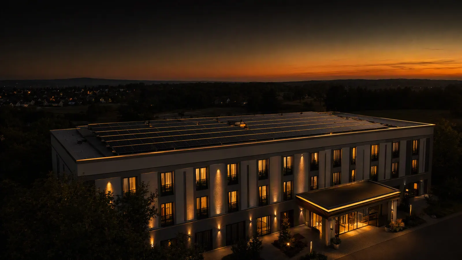 Hoteldach mit Photovoltaikmodulen in der Abenddämmerung